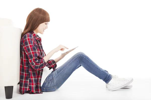 Joven mujer tocando la tableta y sentado en el suelo — Foto de Stock