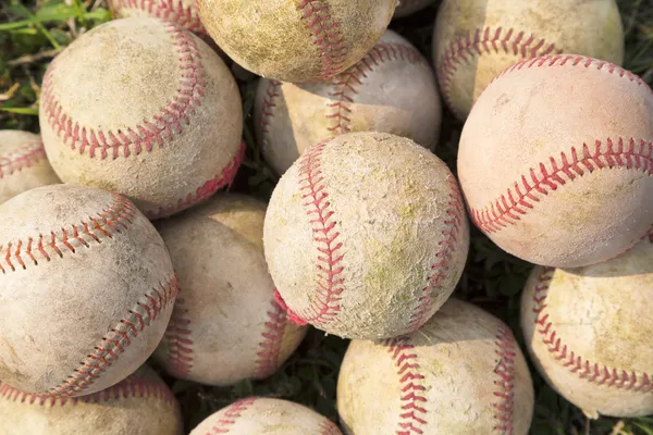 Opstapelen een stapel oude honkbal in het groen — Stockfoto