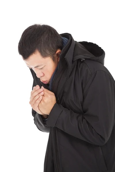 Young man blowing to warm hands in cold day — Stock Photo, Image