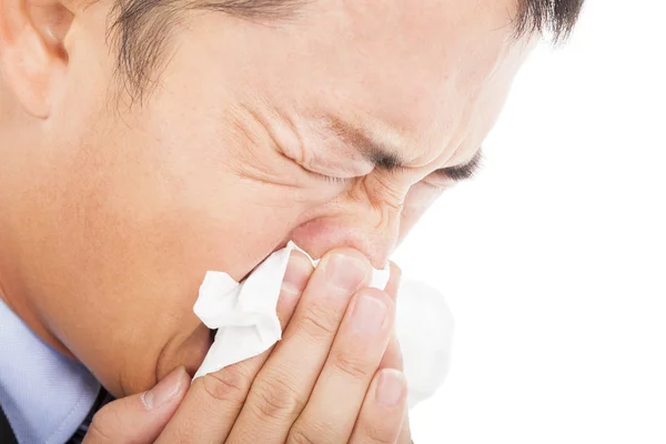 Young man is sneezing with toilet paper — Stock Photo, Image