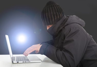 Karanlıkta bir dizüstü bilgisayar ile çalışan hacker