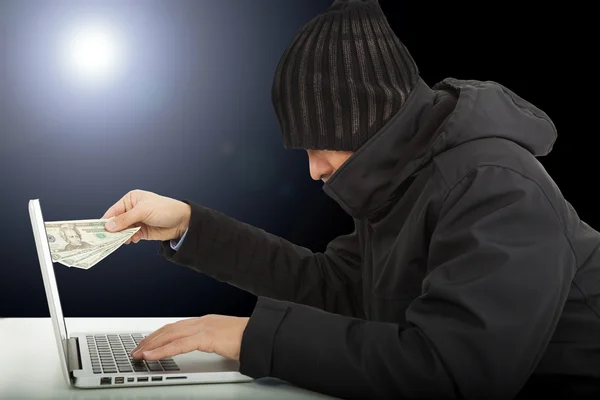 Hacker de computador roubando dinheiro na escuridão — Fotografia de Stock