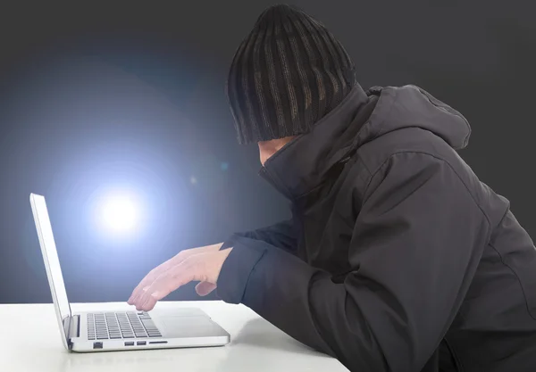 Hacker working with a laptop computer in the darkness — Stock Photo, Image