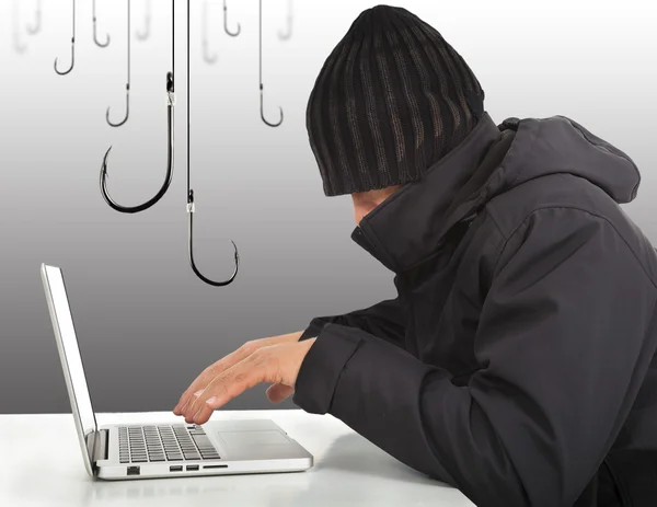 Hacker working with a laptop computer and hooks — Stock Photo, Image