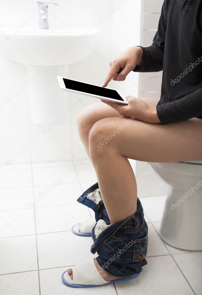 young man in toilet using tablet