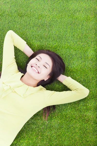 Mulher sorridente deitada no prado — Fotografia de Stock