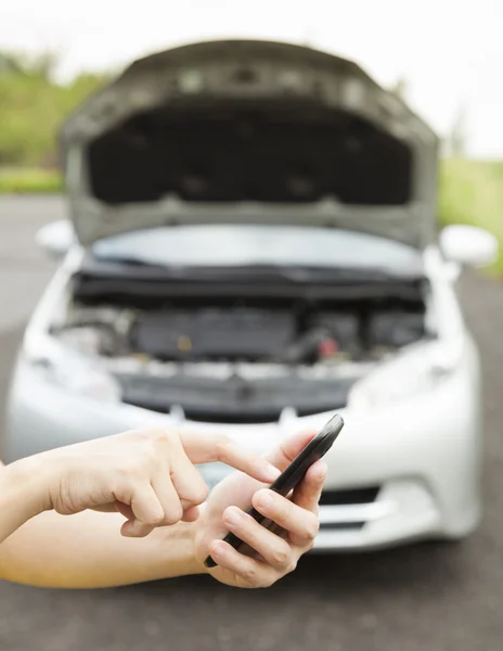 Using cell phone to dial service number , a broken car — Stock Photo, Image