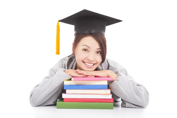 Asian smiling student leaning on stacked books — Stock Photo, Image