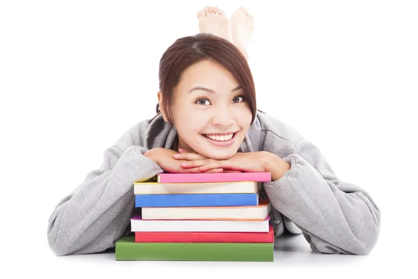 Asian young student lying on stacked books — Stock Photo, Image