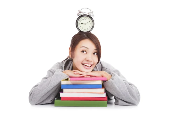 Happy young student looking clock with books — Stock Photo, Image