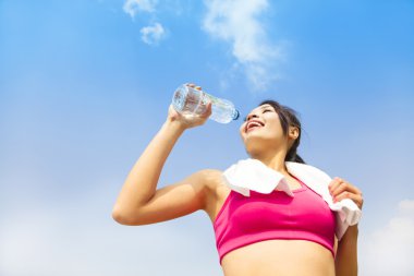 Spor sonrası su içen genç bir kadın.