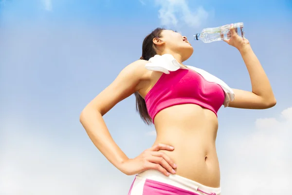 Молодая женщина пьет воду после бега — стоковое фото