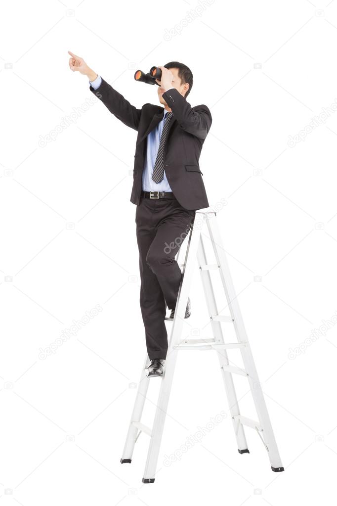 asian businessman using binoculars standing on stair