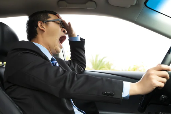 Erschöpfter Fahrer gähnt und fährt Auto — Stockfoto