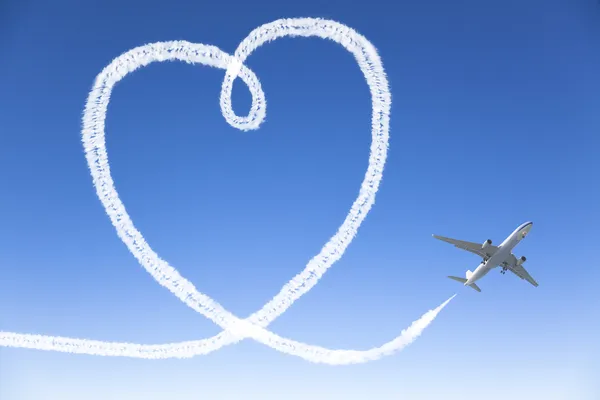 Letadlo letí s tvarem srdce v oblacích — Stock fotografie