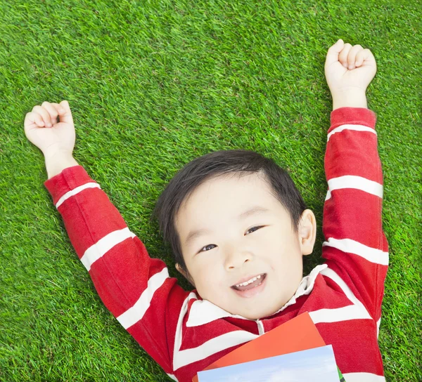 Beauté sourire enfant garçon au repos et la main vers le haut avec des livres — Photo