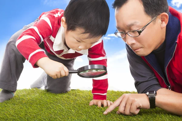 Father and kid with magnifying glass to discover — Stock Photo, Image