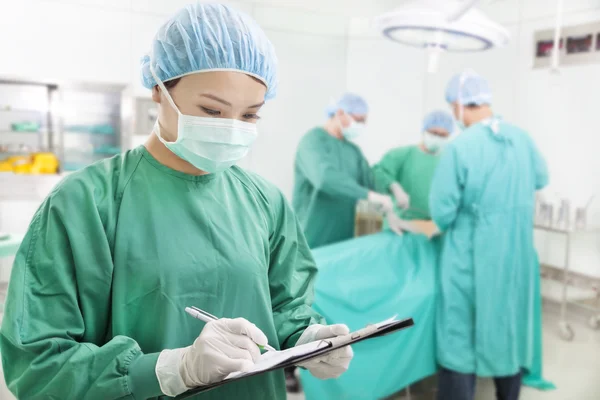 Kvinna kirurger skriva poster i formulär — Stockfoto