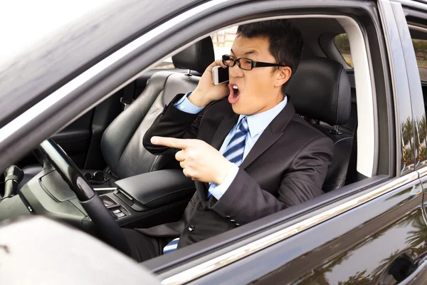 Woedende zakenman praten met mobiele telefoon in de auto — Stockfoto