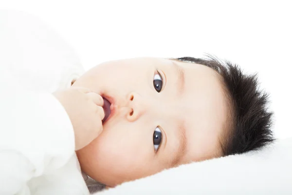 Aranyos baba szar a hüvelykujját az ágyban fekve — Stock Fotó