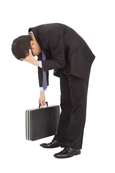 Afflictive businessman stoop and hold his head Stock Picture