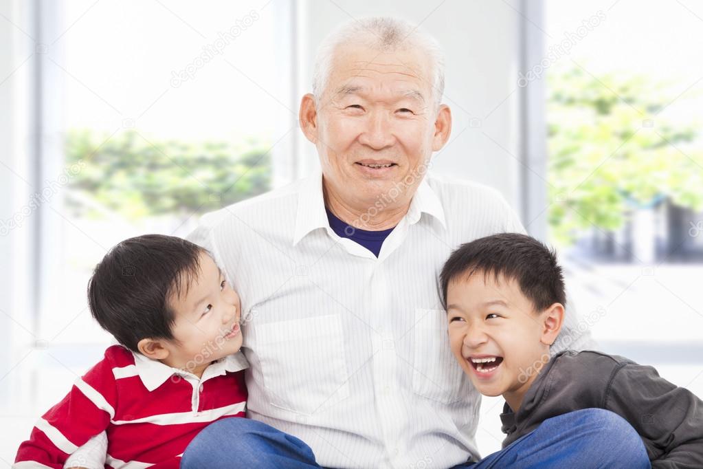 happy grandfather and grandchildren playing at home