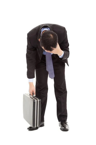 Afflictive businessman stoop and hold his head Stock Photo