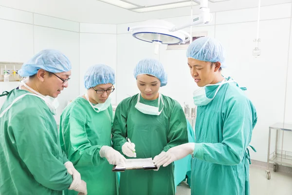 Surgeons discussing about something in operating theater — Stock Photo, Image