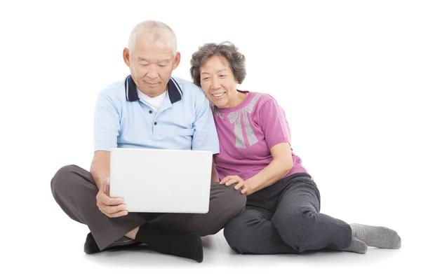 Glückliches Senioren-Paar schaut zu oder lehnt sich mit Laptop an — Stockfoto