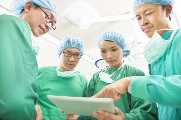 The surgeons useing tablet to discuss operating procedure — Stock Photo, Image