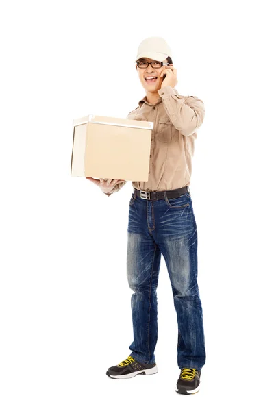 Чоловік доставки розмовляє з мобільним телефоном і тримає посилку — стокове фото