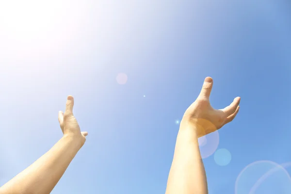 Twee handen met de geopende handpalmen laatste omhoog naar de blauwe hemel — Stockfoto