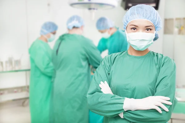Cirurgiões femininos confiantes cruzaram as mãos com equipes — Fotografia de Stock