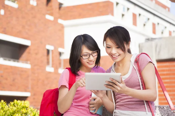 Two students using a tablet to discuss homework — Stock Photo, Image