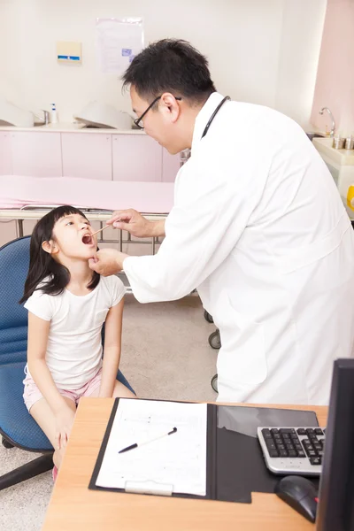 Pediatra examinando la garganta del niño con depresor de la lengua — Foto de Stock