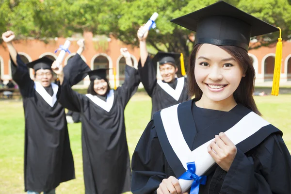 College-Absolvent mit glücklichen Mitschülern — Stockfoto