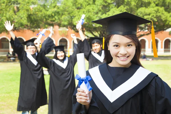 Beautiful female college graduate holding a diploma at ceremony — Stock Photo, Image