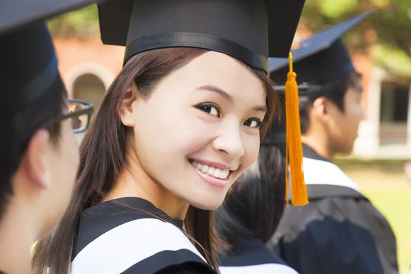 Sonriente mujer destacándose de un grupo de graduación —  Fotos de Stock