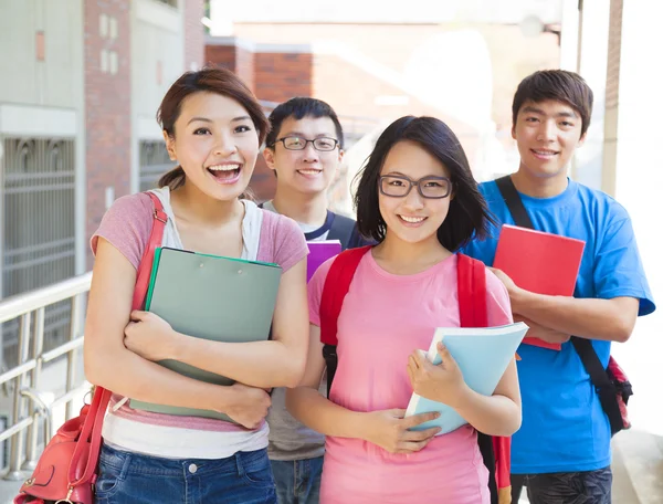 Uśmiechający się uczniowie stojąc razem w kampusie — Zdjęcie stockowe