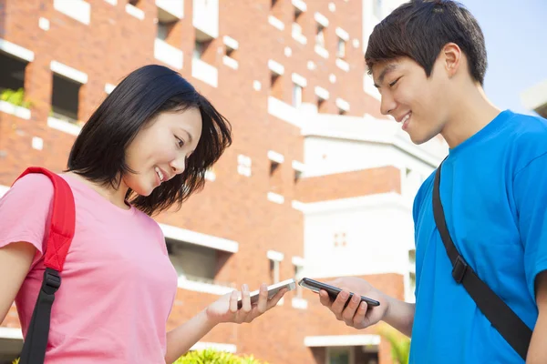 Giovani studenti stanno usando gli smartphone per mostrare qualcosa — Foto Stock