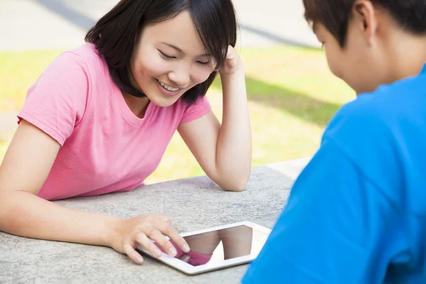 Ung flicka med en tablett med en vän eller käresta — Stockfoto