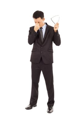 young businessman rubbing his eyes and holding glasses clipart