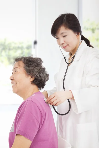 Домашний врач измеряет давление у пожилых женщин — стоковое фото