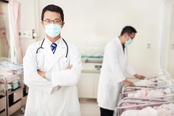 Médico e assistente de cuidados recém-nascidos bebês na sala de bebê — Fotografia de Stock