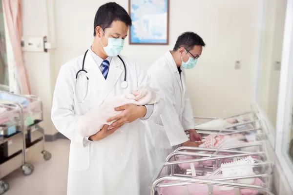 Ginecologista médico segurando um bebê recém-nascido — Fotografia de Stock