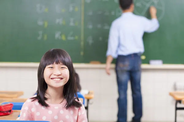 Glada skolbarn i klass med lärare — Stockfoto