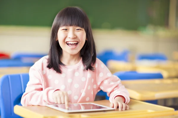 Glückliches kleines Mädchen mit Tablet oder ipad — Stockfoto