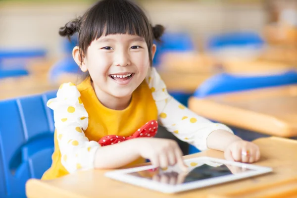 Criança sorrindo usando tablet ou ipad — Fotografia de Stock