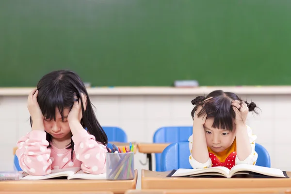 Дві сумні дівчата роблять домашнє завдання — стокове фото