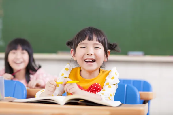 Enfants heureux étudiant dans une salle de classe — Photo